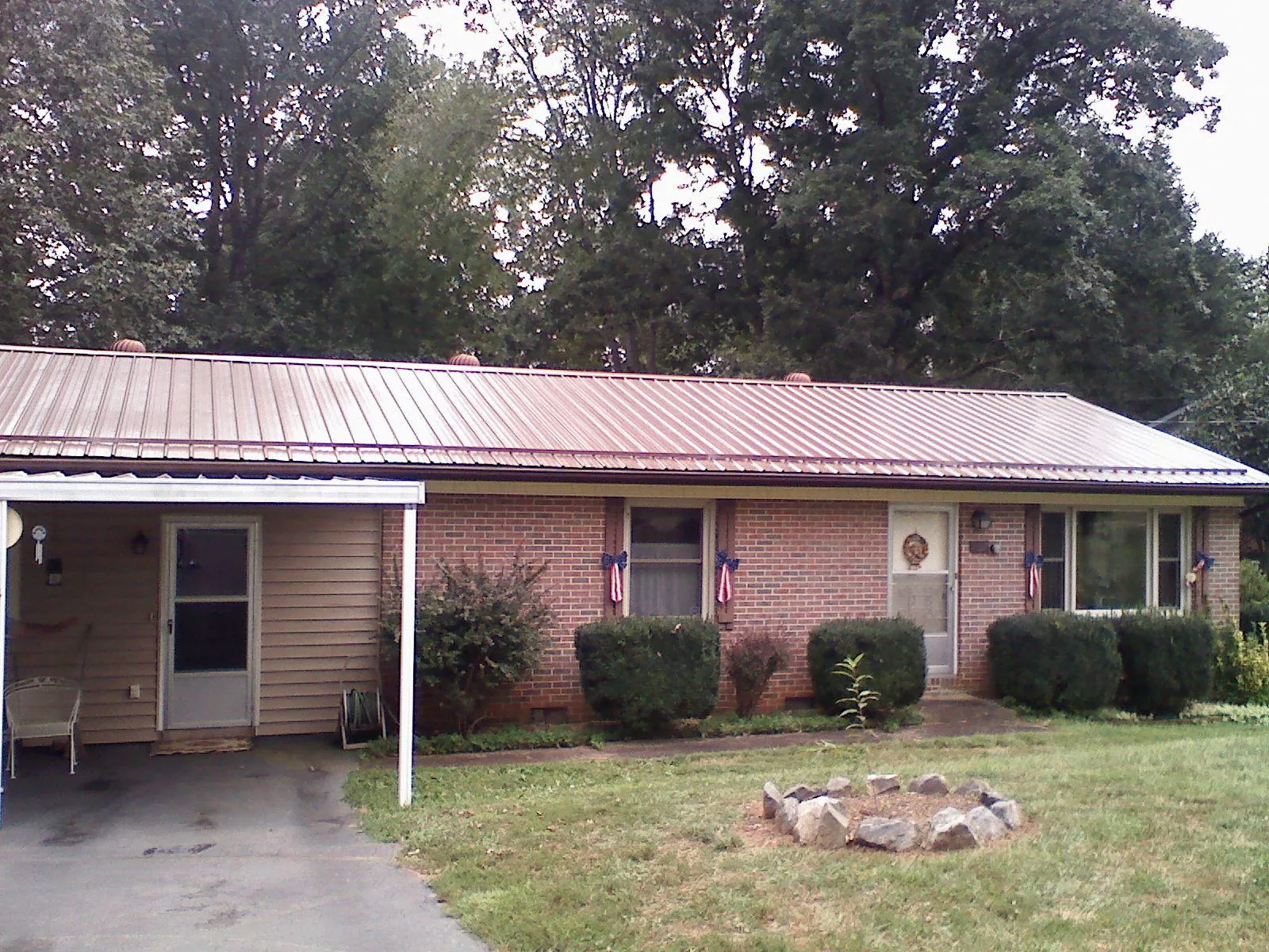 Bronze metal roof and carport on a brick ranch home — Roof Repair work by our crew in Mckeesport