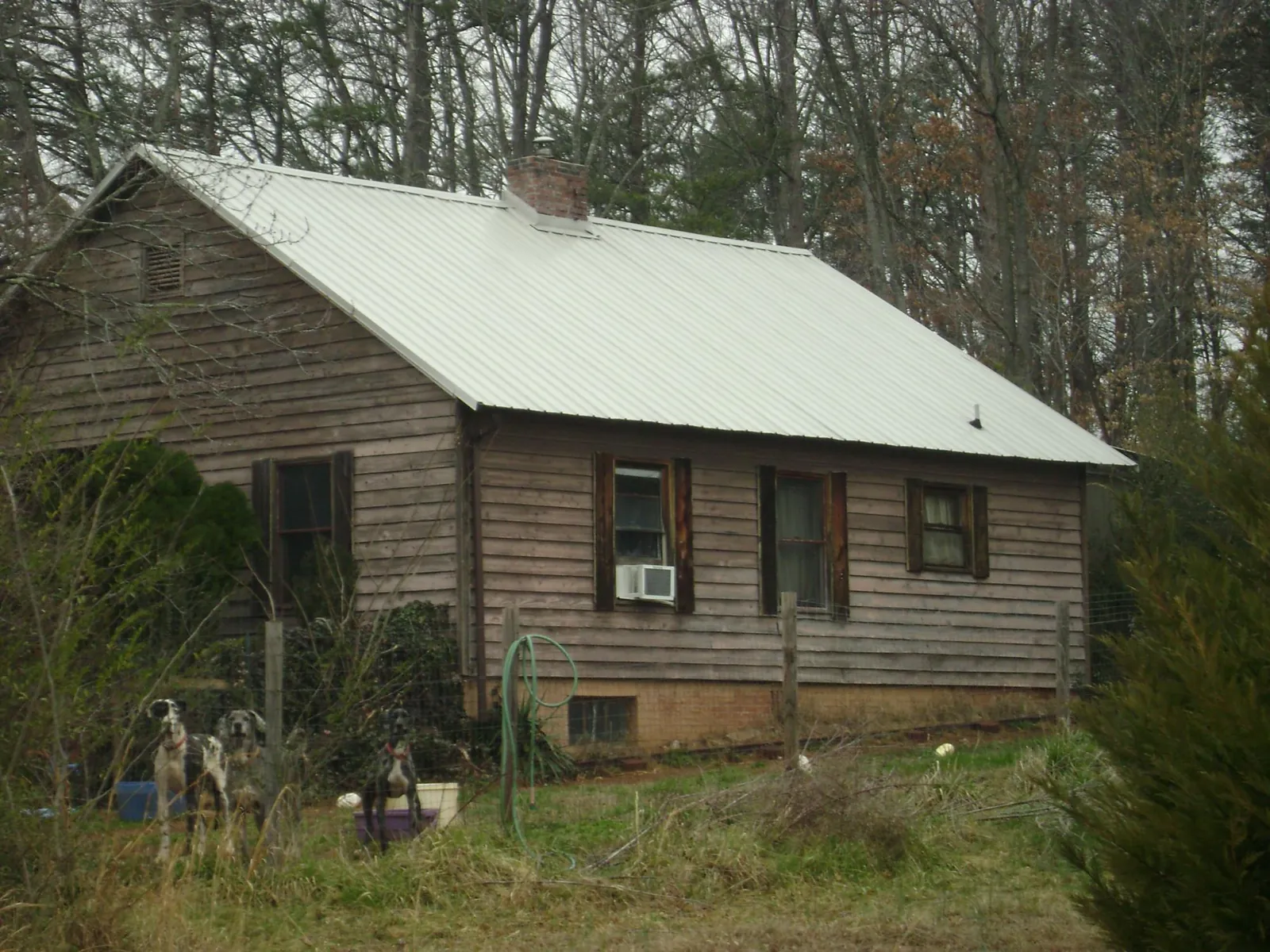 White metal roof on an old wood sided farmhouse, from a Metal Roof Installation job in Mckeesport